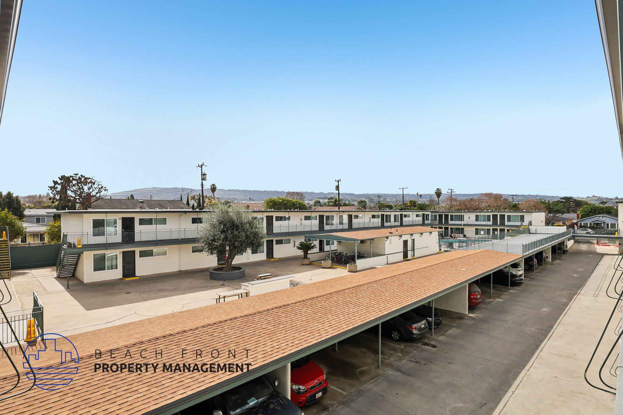 A parking lot with a sign that says "Beach Front Property Management".